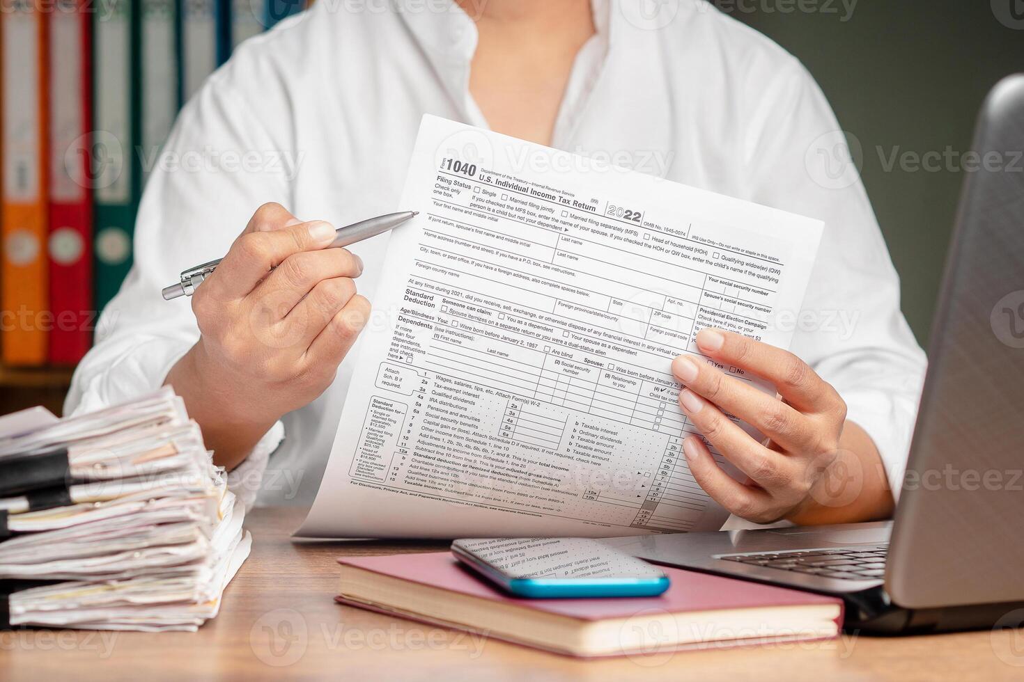 Hand holding of form 1040. U.S. individual income tax return while sitting at the table in the office. Close-up. photo