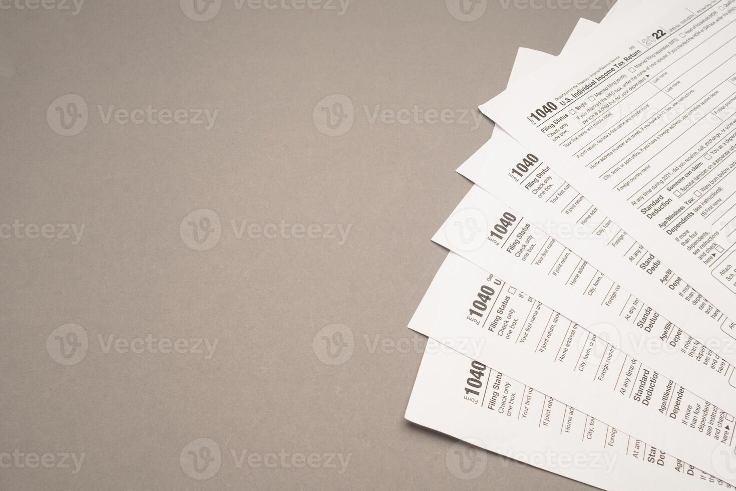 TAX form on a gray background. Assistance with filing tax forms and calculations photo