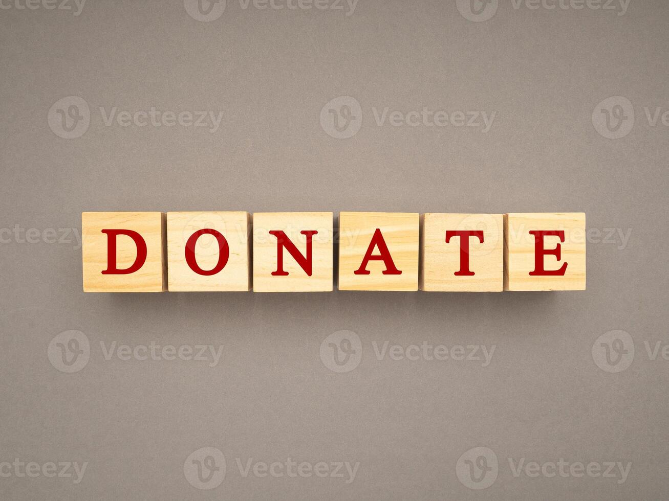 Top view of wooden cubes with the letters DONATE on a gray background photo