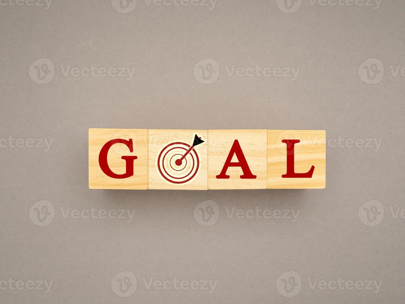 Wooden cubes with the letters GOAL and dartboard on a gray background photo