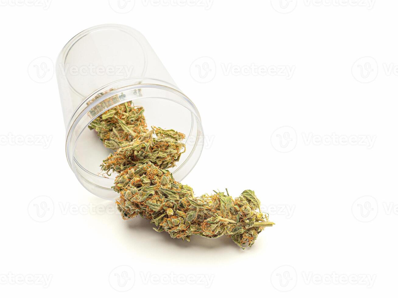 Dry marijuana buds outside of a jar on a white background. Close-up photo
