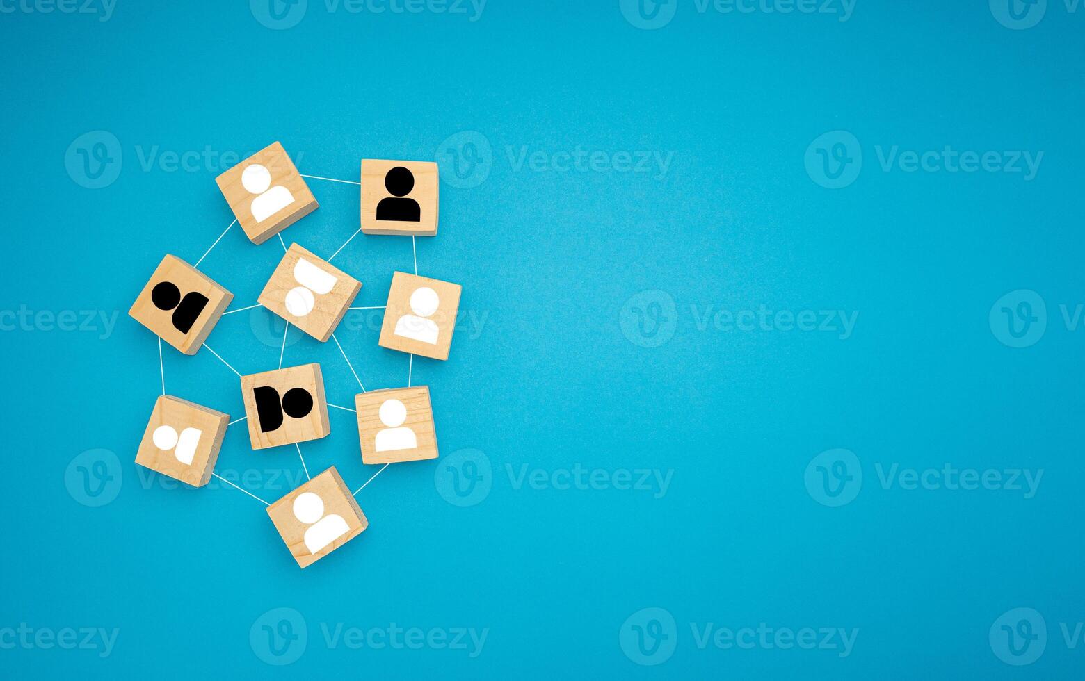 Wooden blocks with black and white human icons scattered on a blue background photo