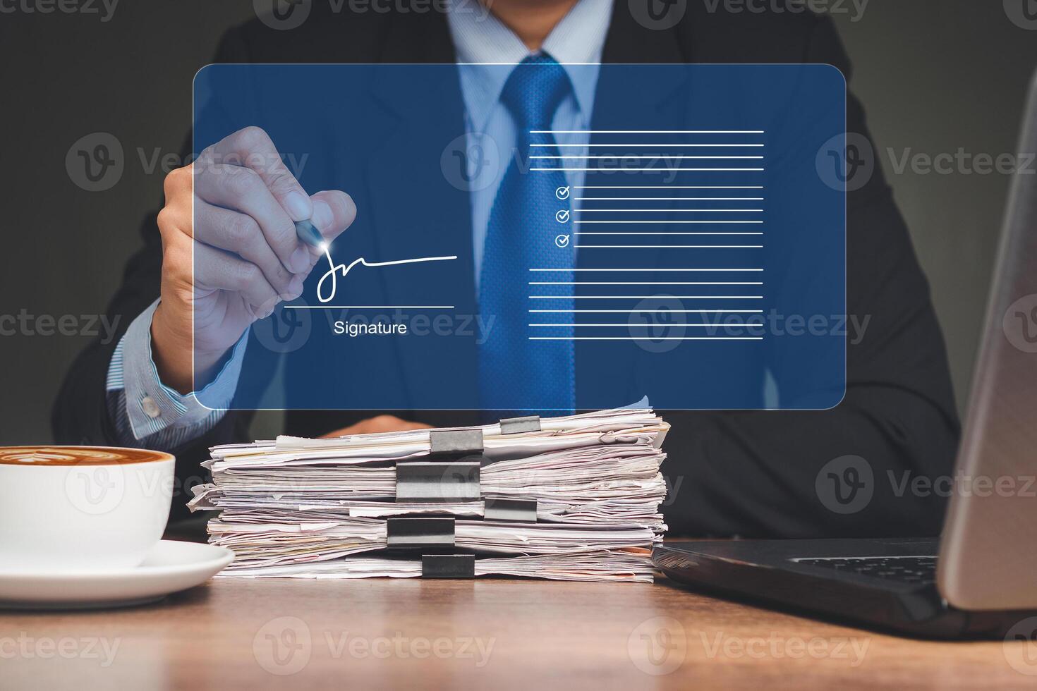 Businessman uses a pen to sign electronic documents on a virtual screen while sitting at the table photo