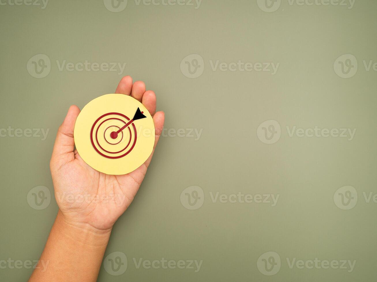 Target made from paper on the hand against a green background photo