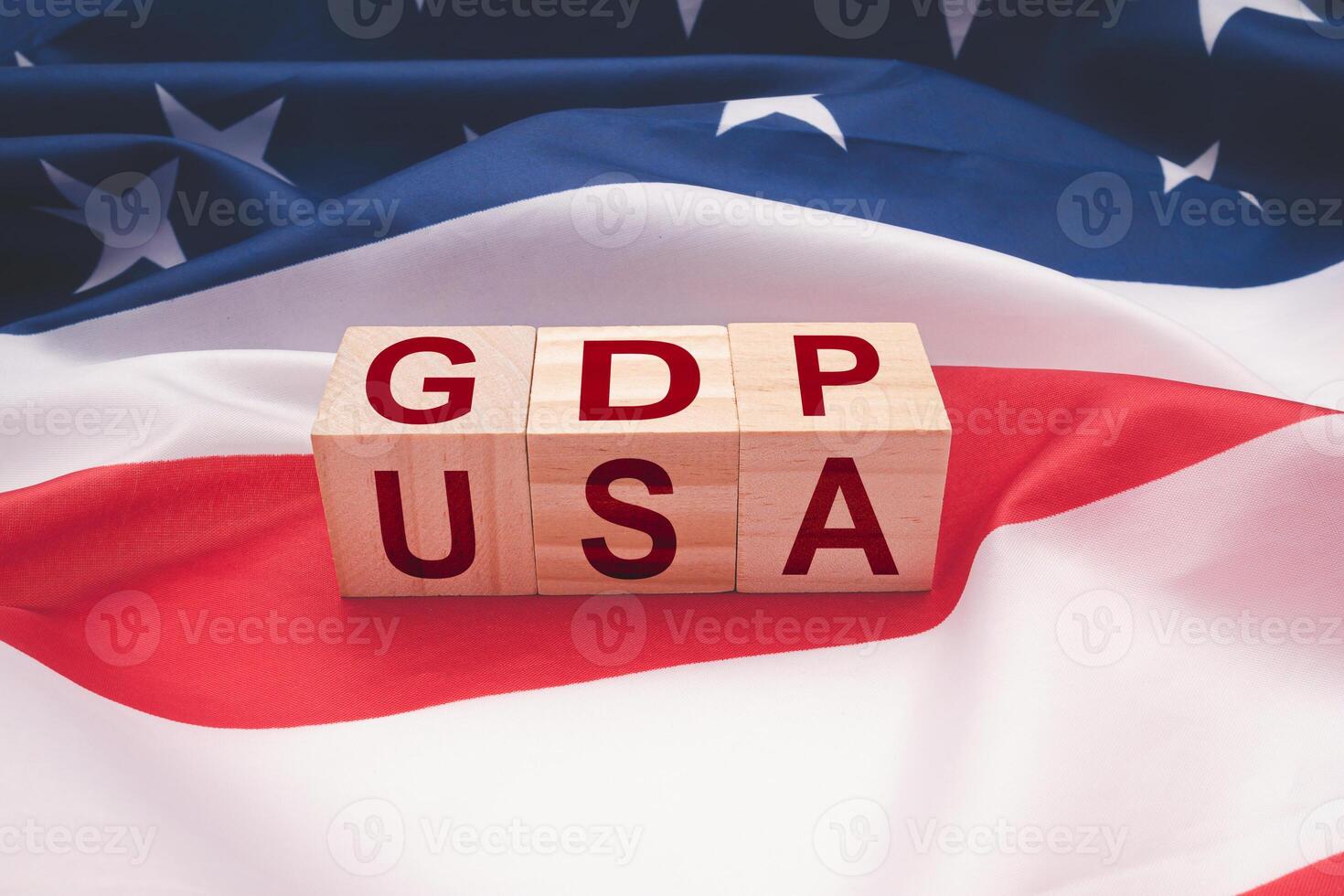 Wooden cubes with the letters GDP and USA on the American flag background photo