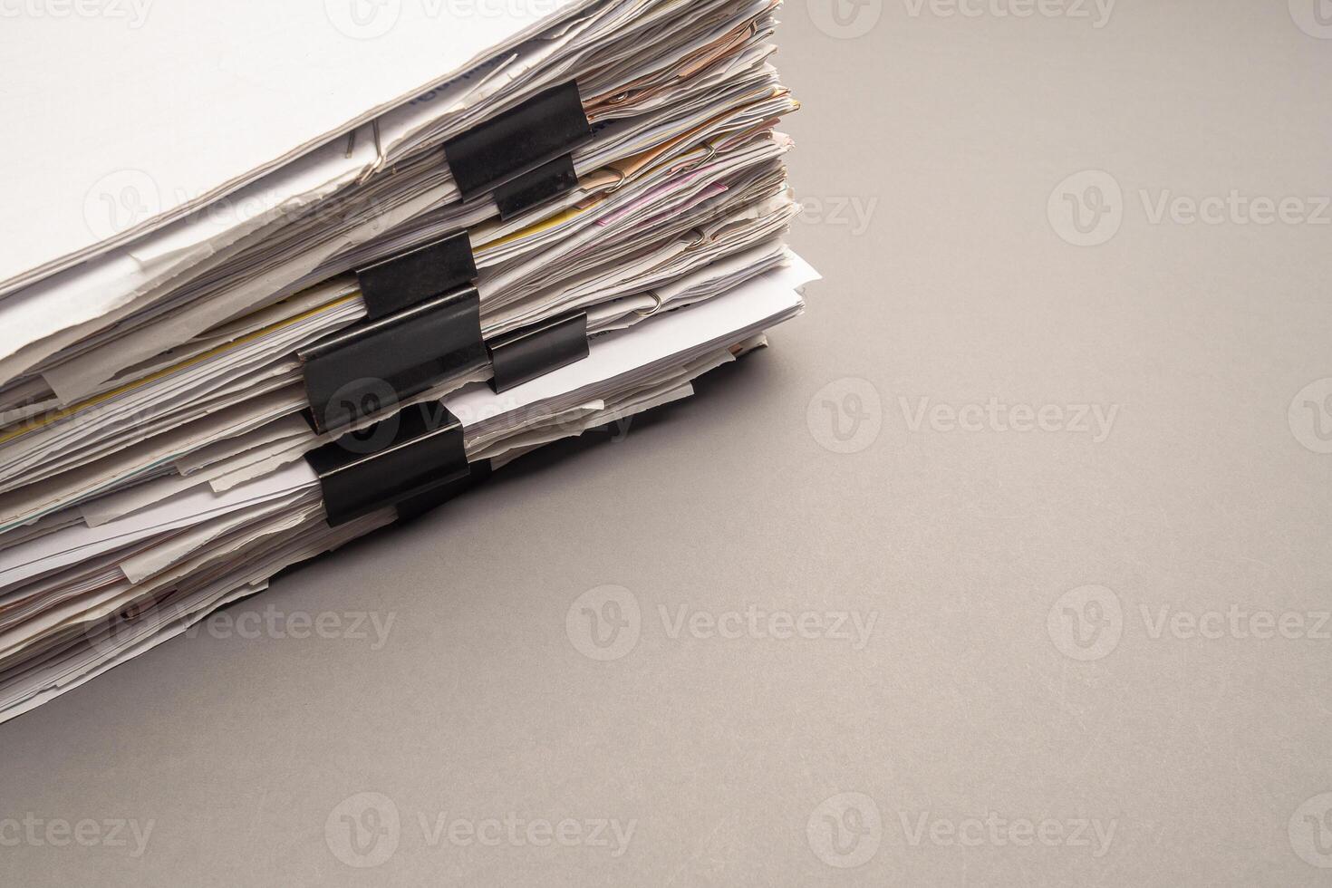 Stack of documents with binder clips on a gray background photo
