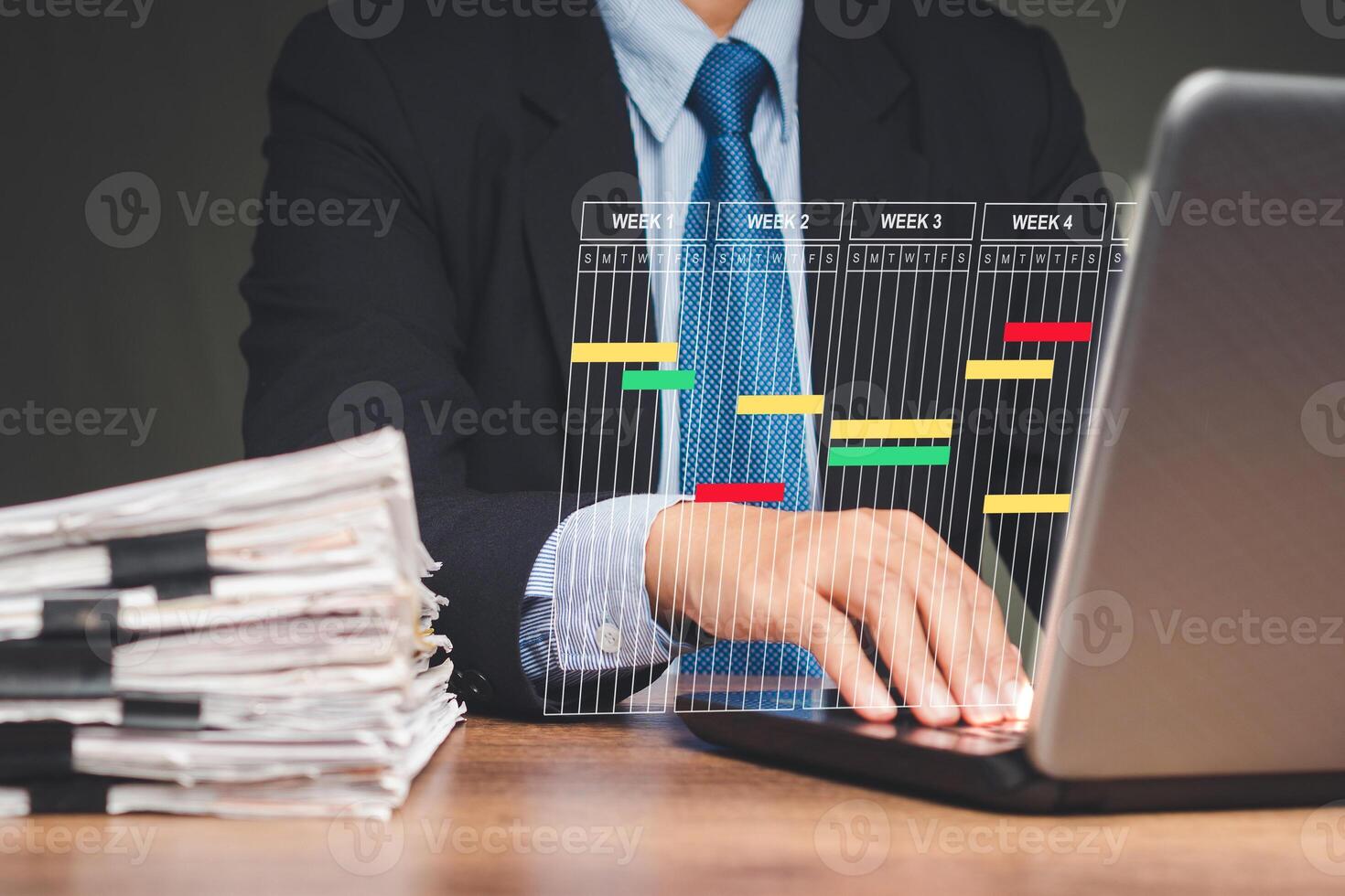 A Project manager working on a laptop and updating tasks and milestones progress planning with a Gantt chart scheduling photo