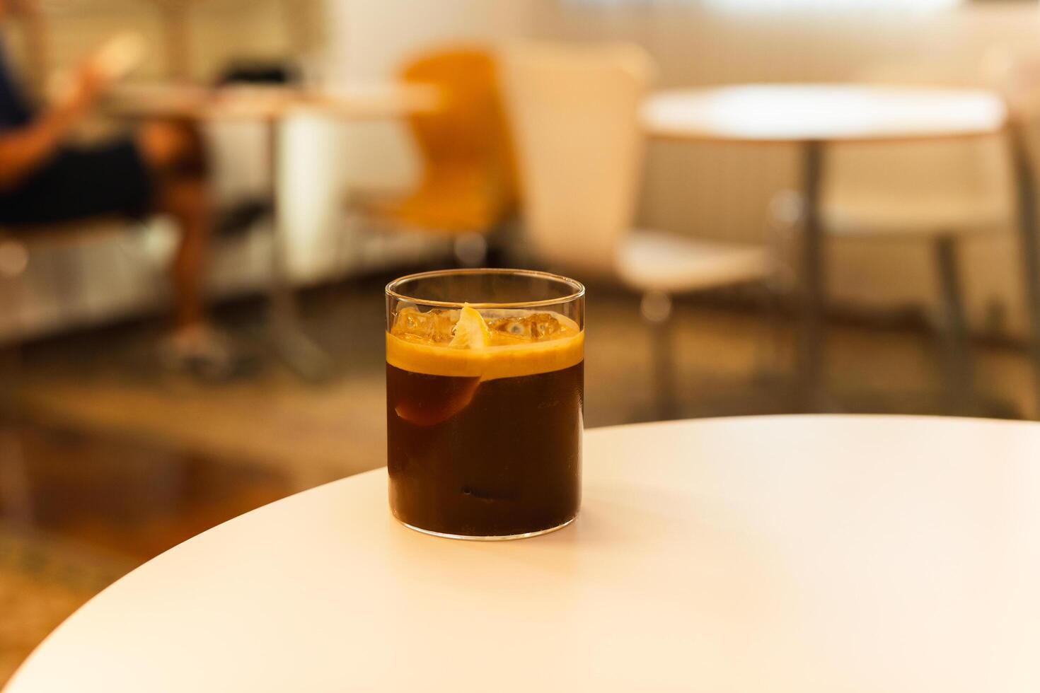 Iced coffee with slice of orange on a table in cafe. photo
