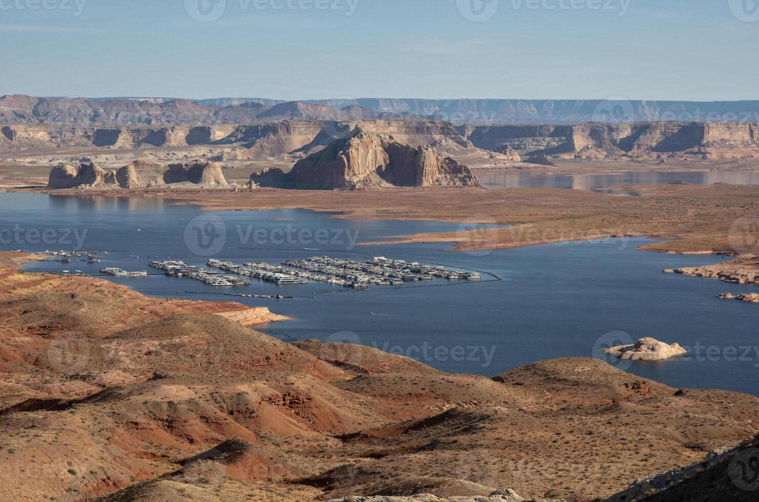 Scenic aerial view of Lake Powell with houseboats docked at the marina, surrounded by desert landscape and rock formations. Concept of water recreation, tourism, and drought awareness photo