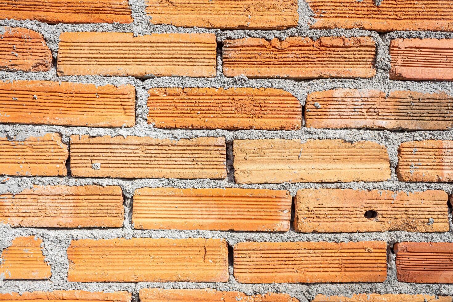 Weathered orange color brick wall for brickwork background design photo