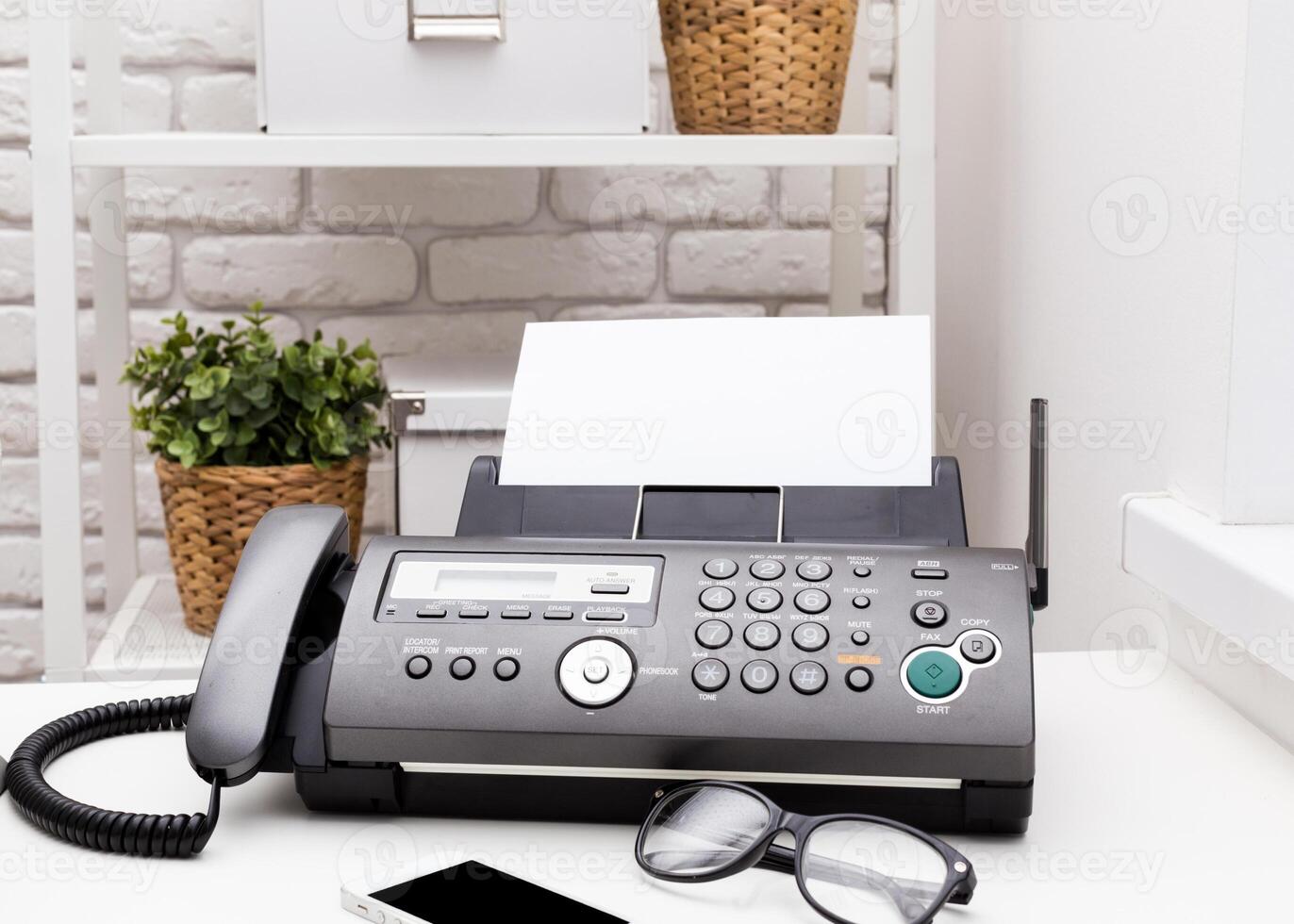 Black office fax machine with paper inside photo