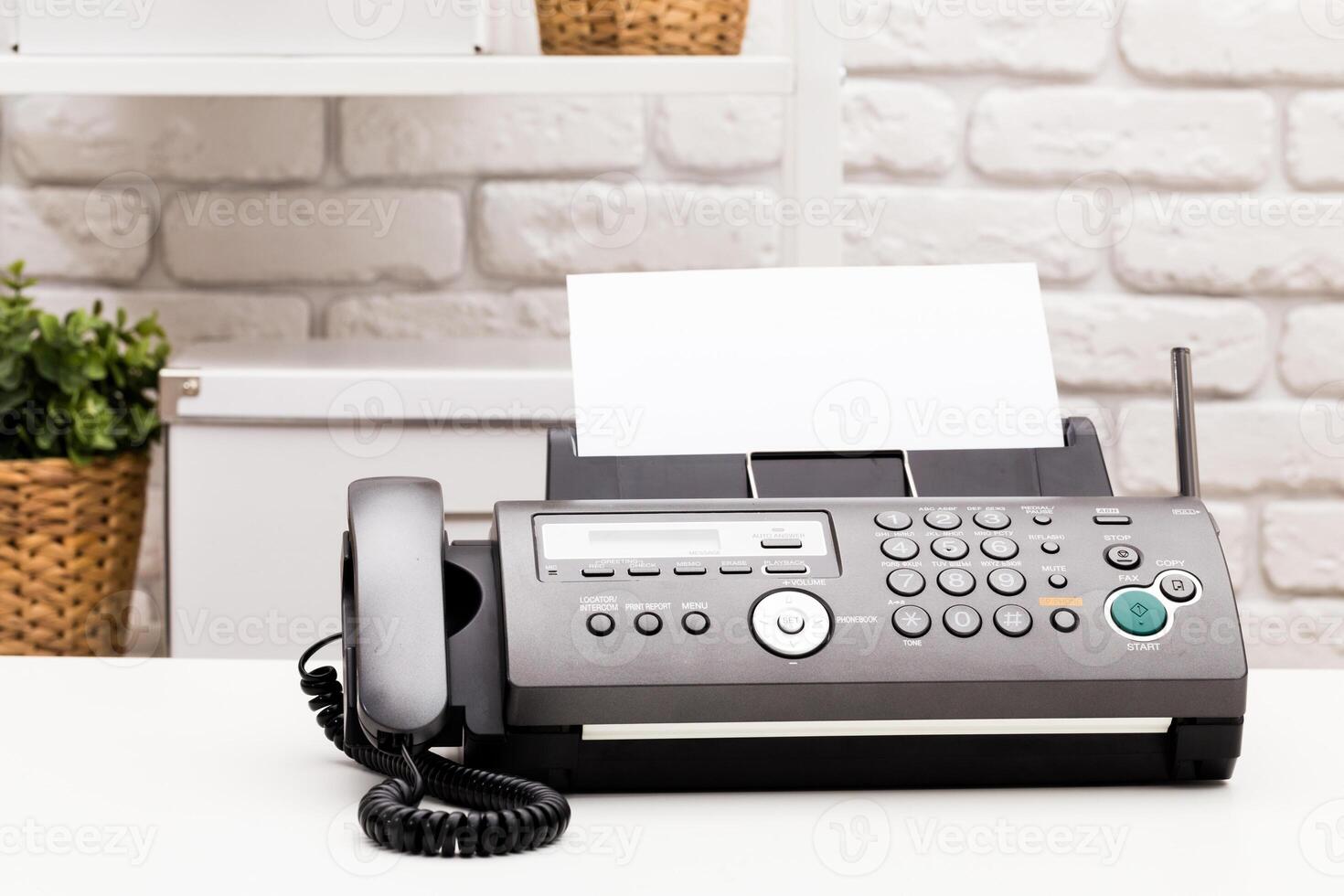 Black office fax machine with paper inside photo