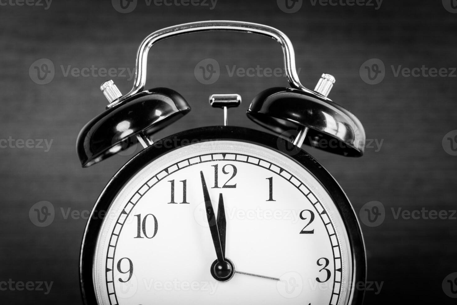 Alarm clock on brown wooden background close up photo