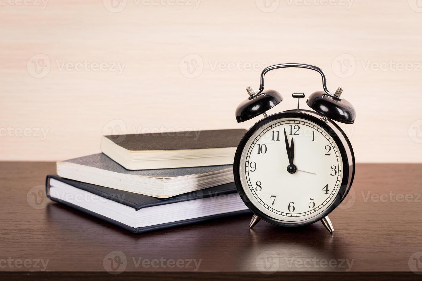 Black alarm clock on the table. Twelve o'clock photo