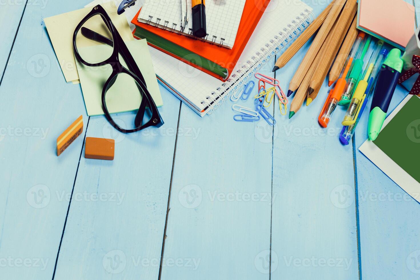 Study workspace with various stationery items and notebooks on a blue wooden table photo