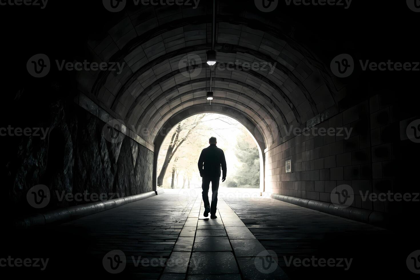 Man walking towards light at end of tunnel symbolizing hope and new beginnings photo