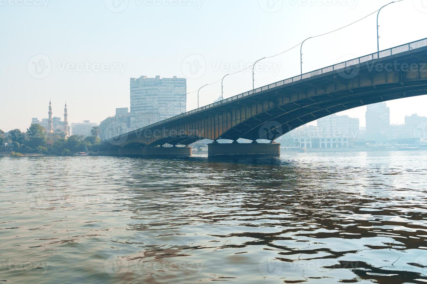 View of a bridge over water with city skyline in the background during a sunny day photo
