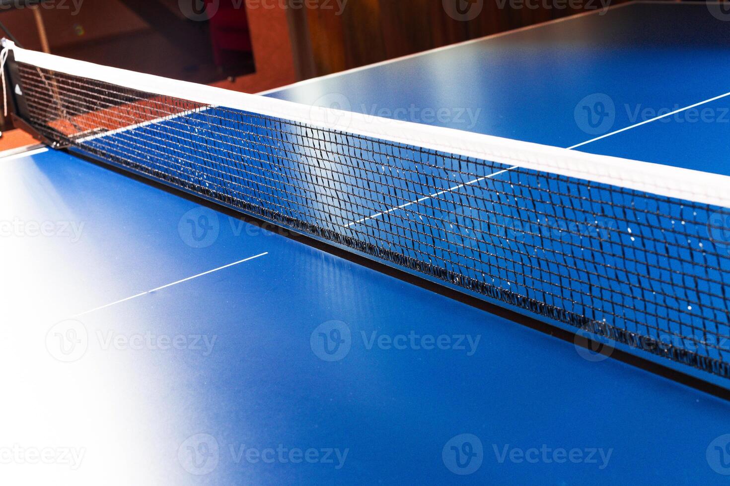 Net on blue ping pong table close up photo
