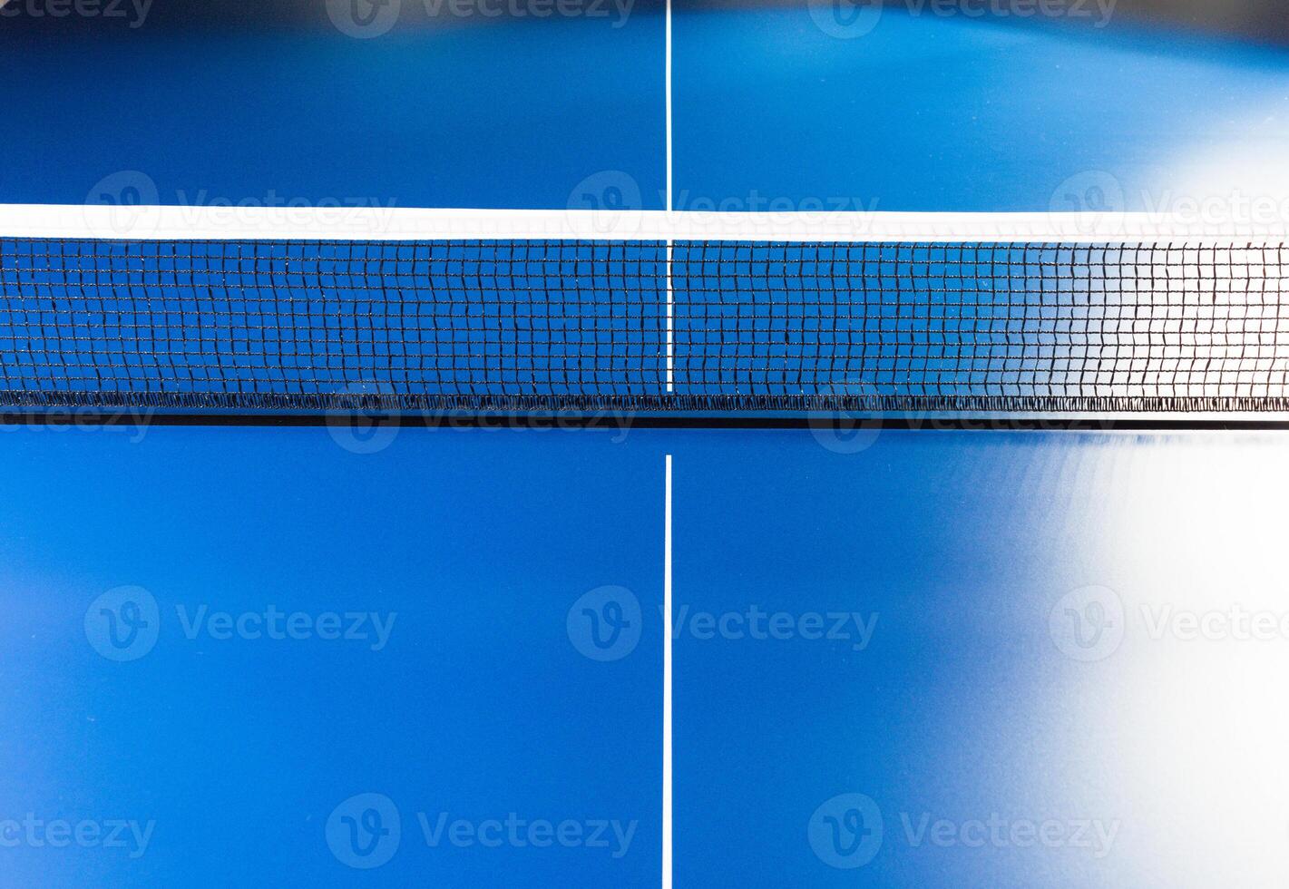 Net on blue ping pong table close up photo