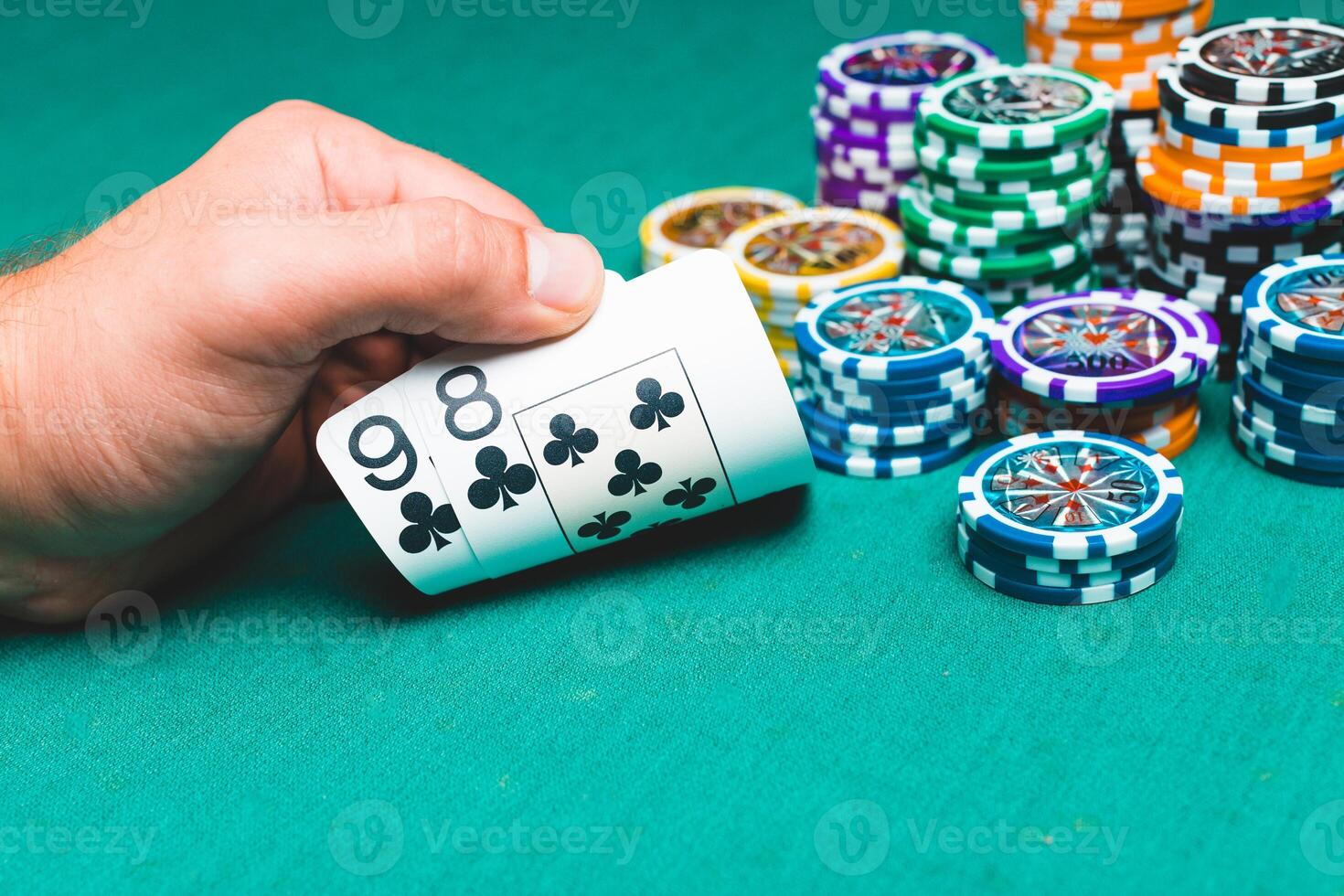 Chips and cards for poker on green table with bokeh photo