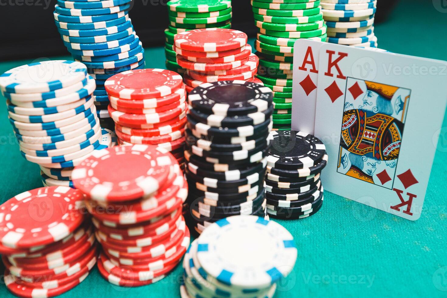 Chips and cards for poker on green table with bokeh photo