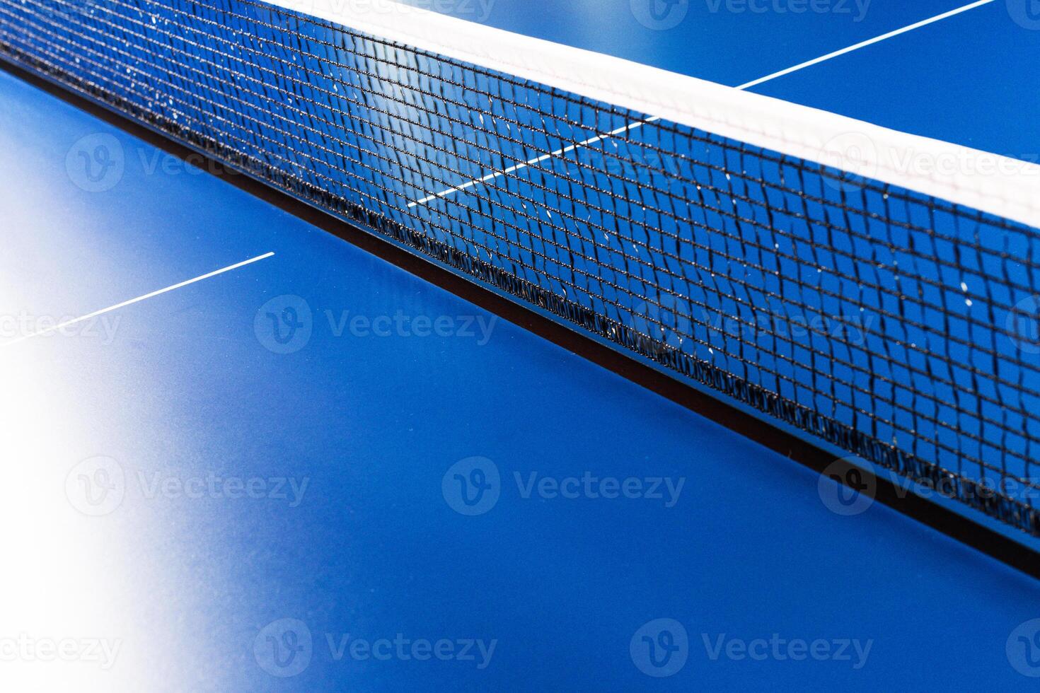Net on blue ping pong table close up photo