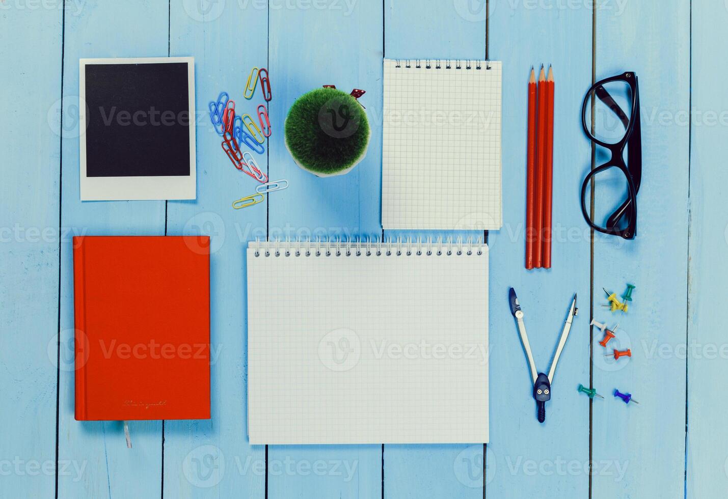 Workspace arrangement with colorful stationery items on a blue wooden table photo
