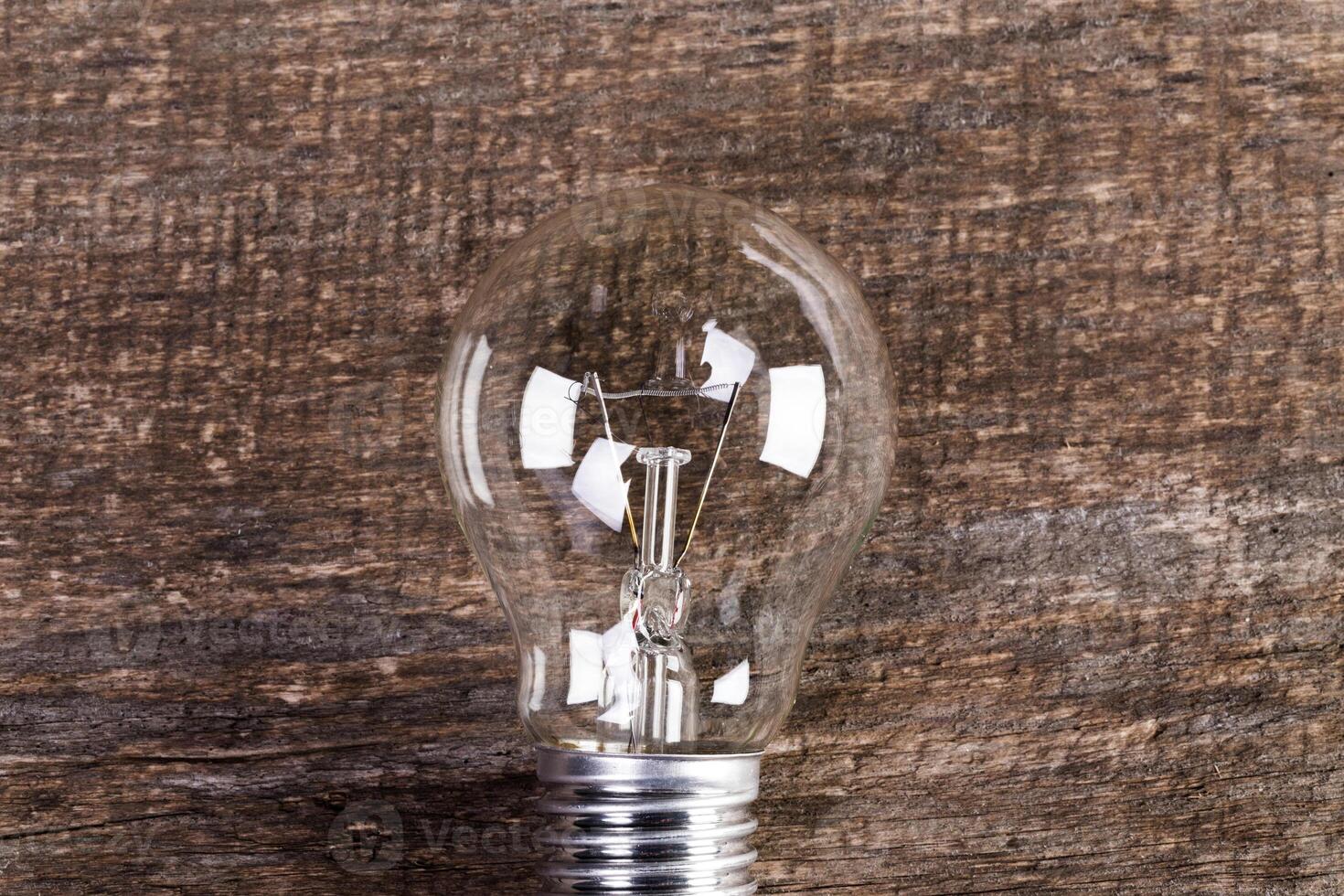Electrical light bulb over wooden background close up photo