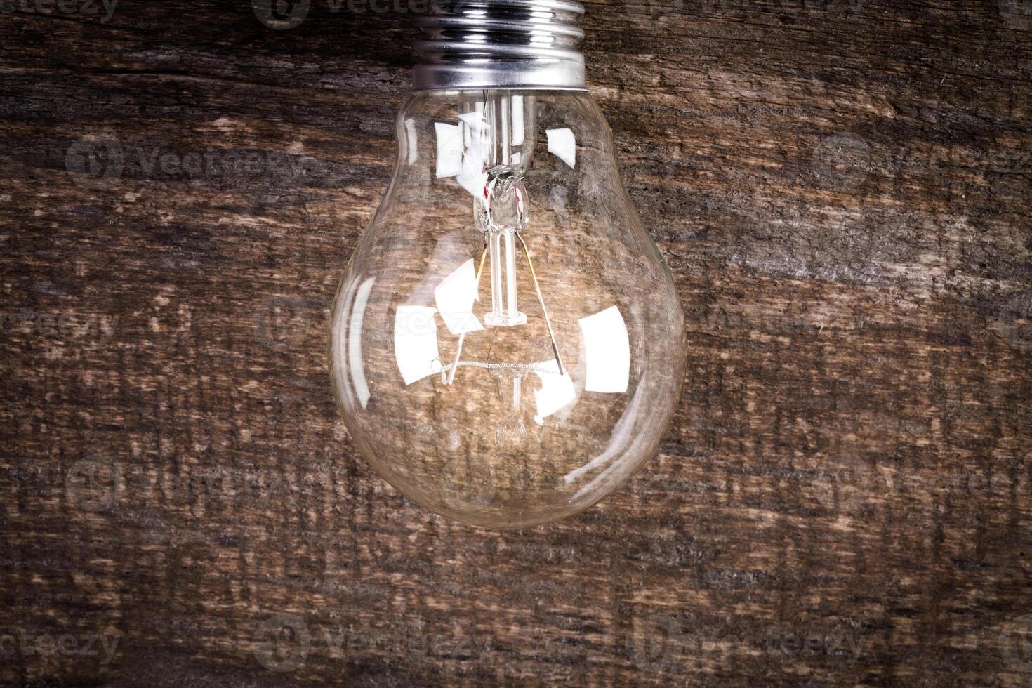 Electrical light bulb over wooden background close up photo
