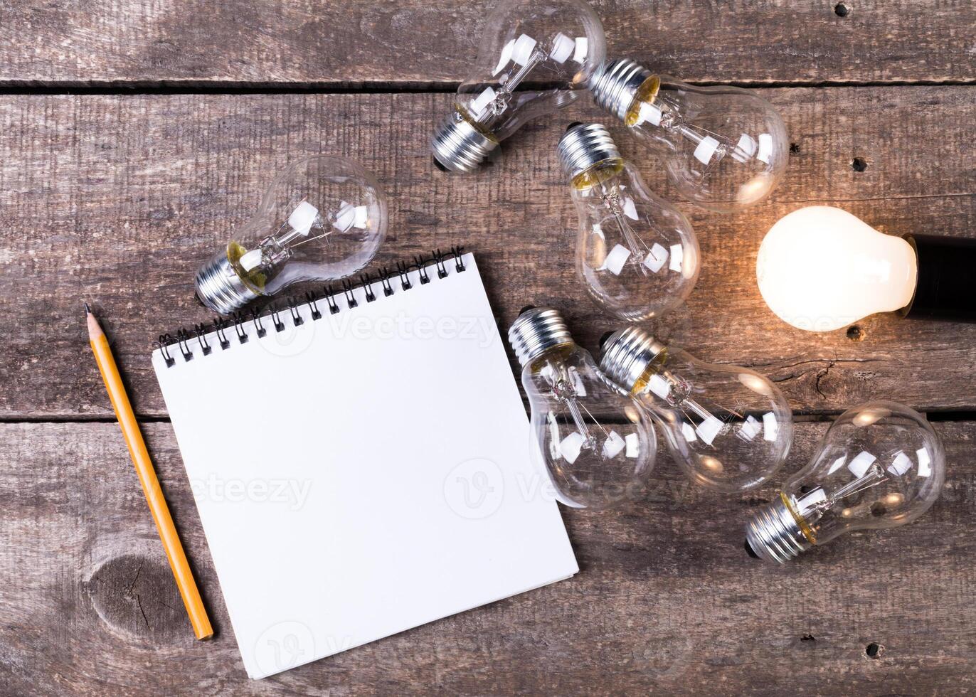 Lightbulb and blank open notepad. Having an idea concept photo