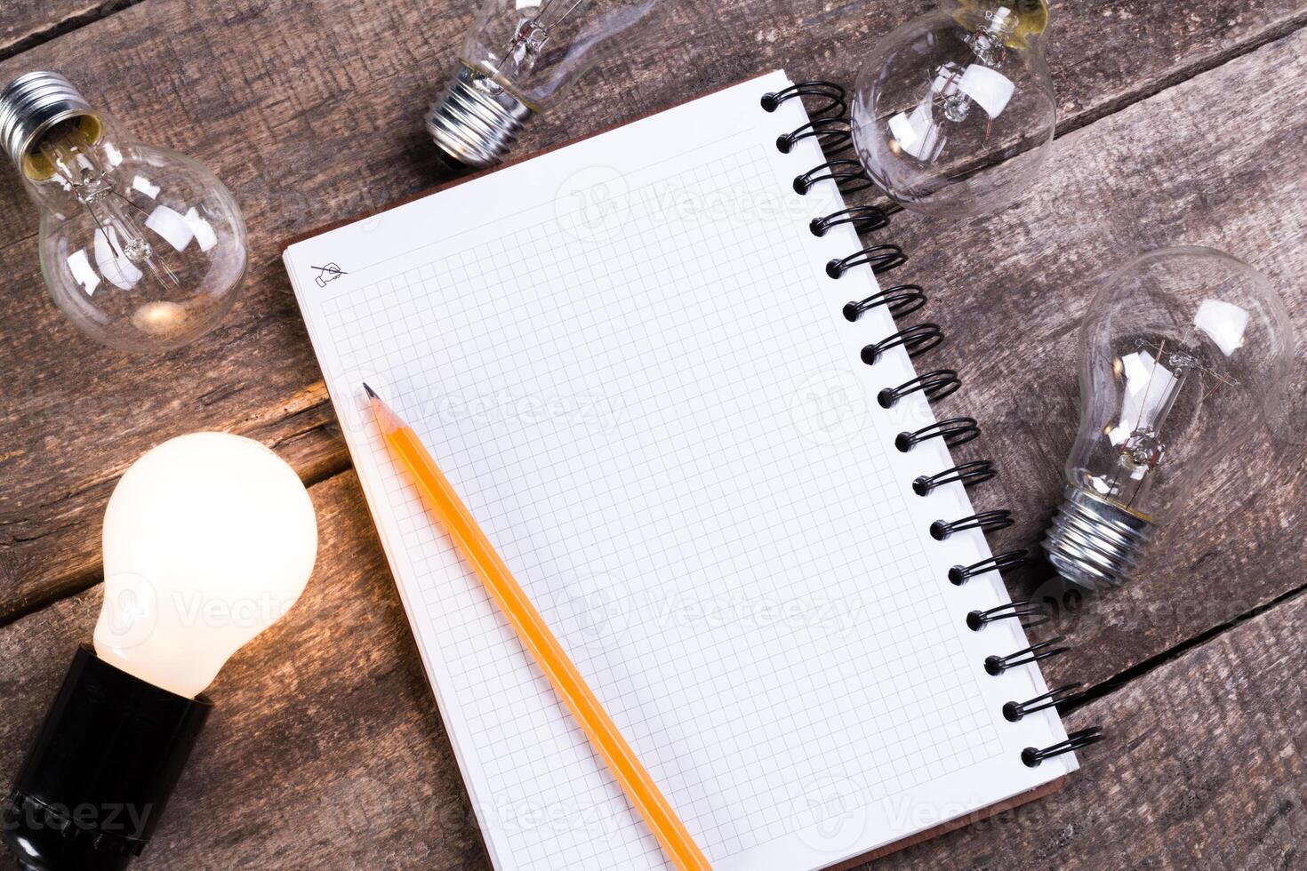 Lightbulb and blank open notepad. Having an idea concept photo