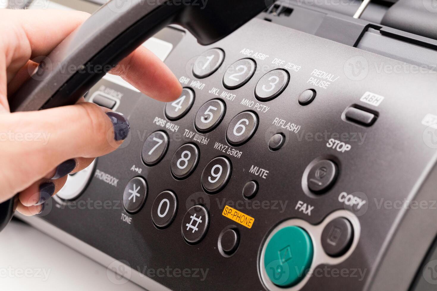 Woman's hand using fax machine close up photo