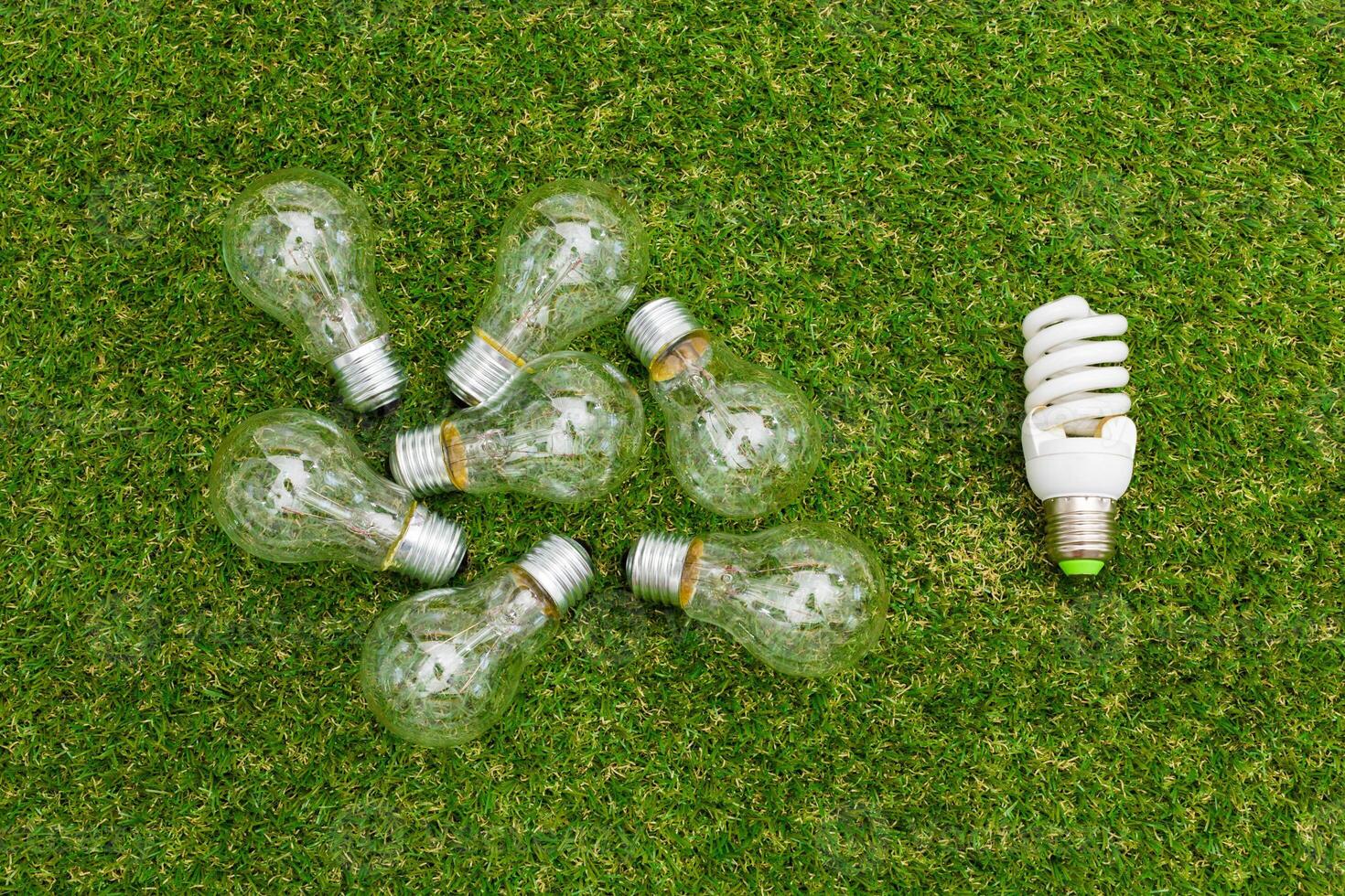 Light bulb in the grass. Saving energy concept photo