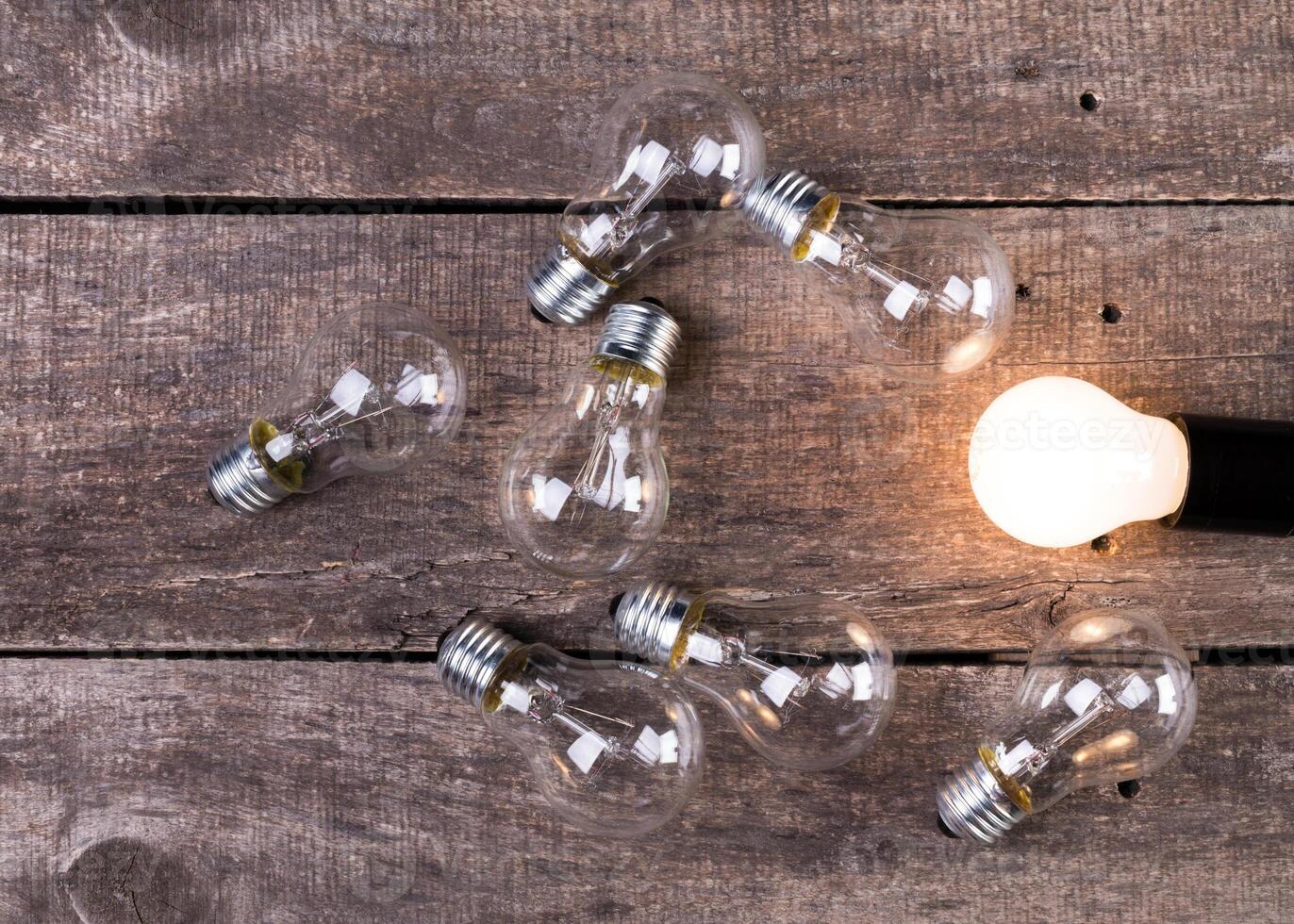Electrical light bulb over wooden background close up photo