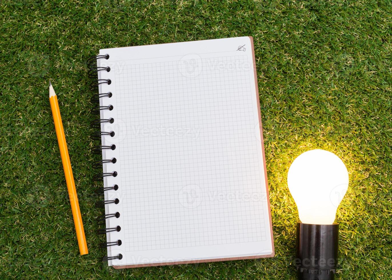 Lightbulb and blank open notepad. Having an idea concept photo