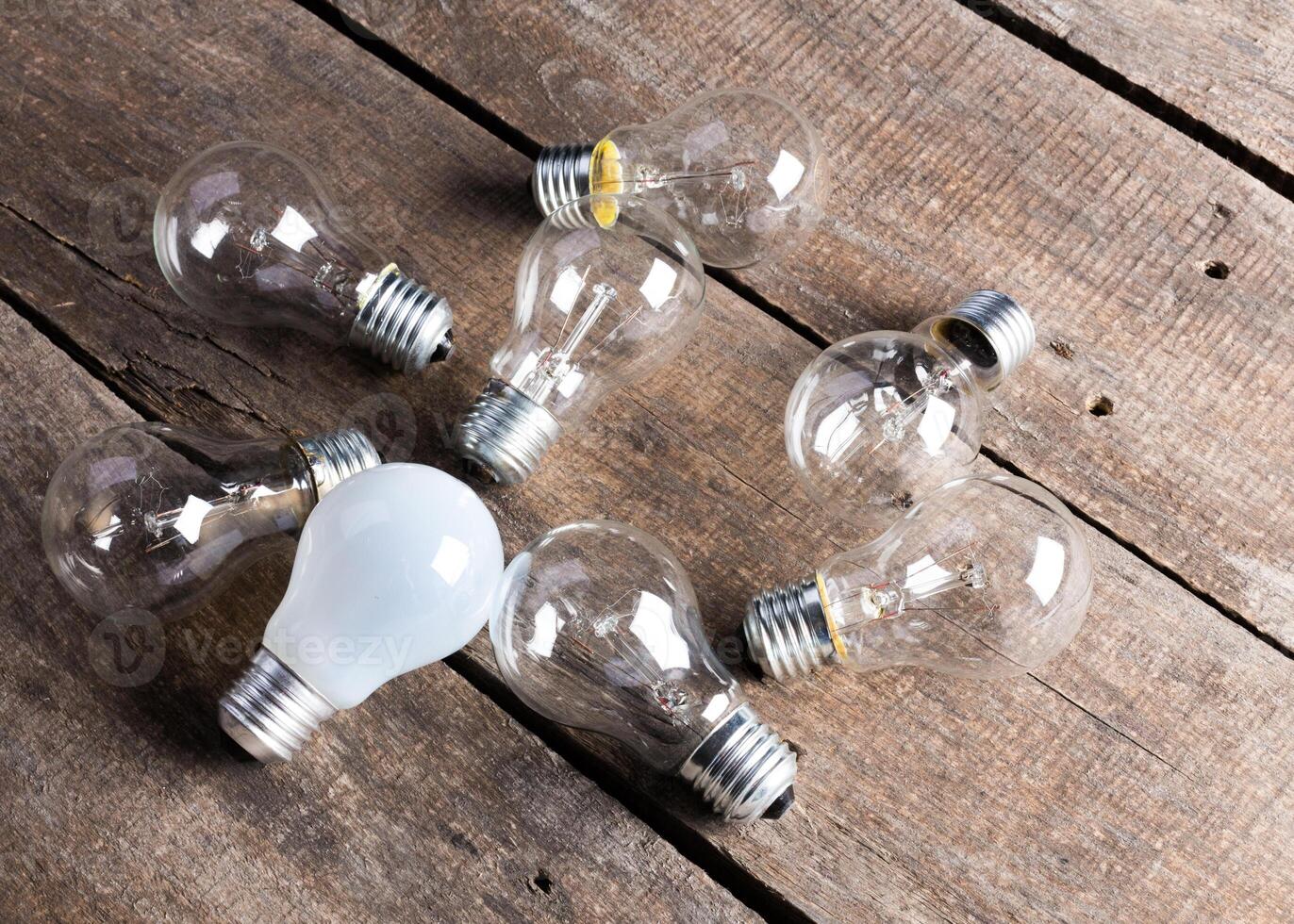 Electrical light bulb over wooden background close up photo