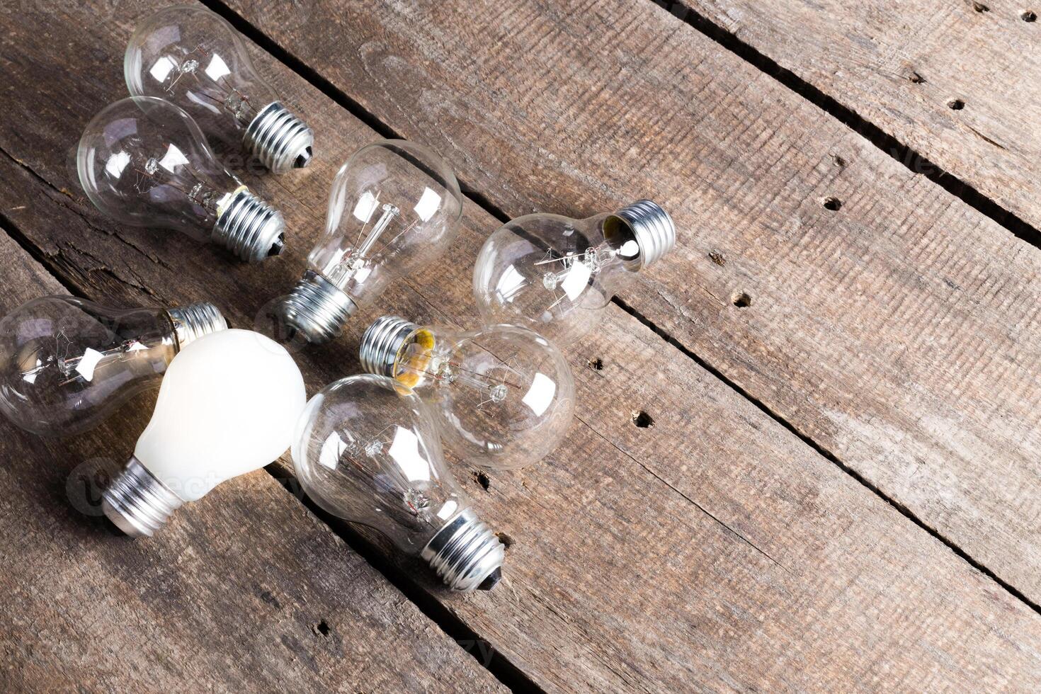 Electrical light bulb over wooden background close up photo
