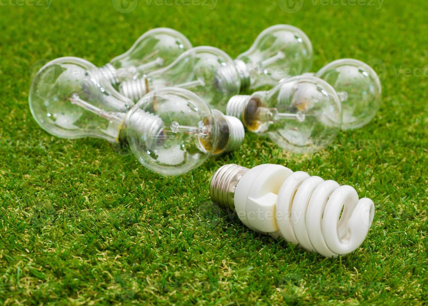 Light bulb in the grass. Saving energy concept photo