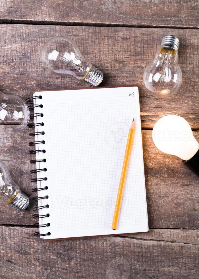 Lightbulb and blank open notepad. Having an idea concept photo