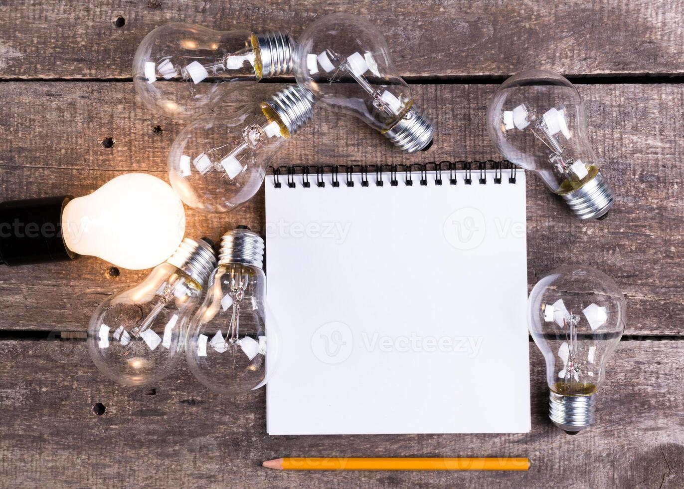 Lightbulb and blank open notepad. Having an idea concept photo