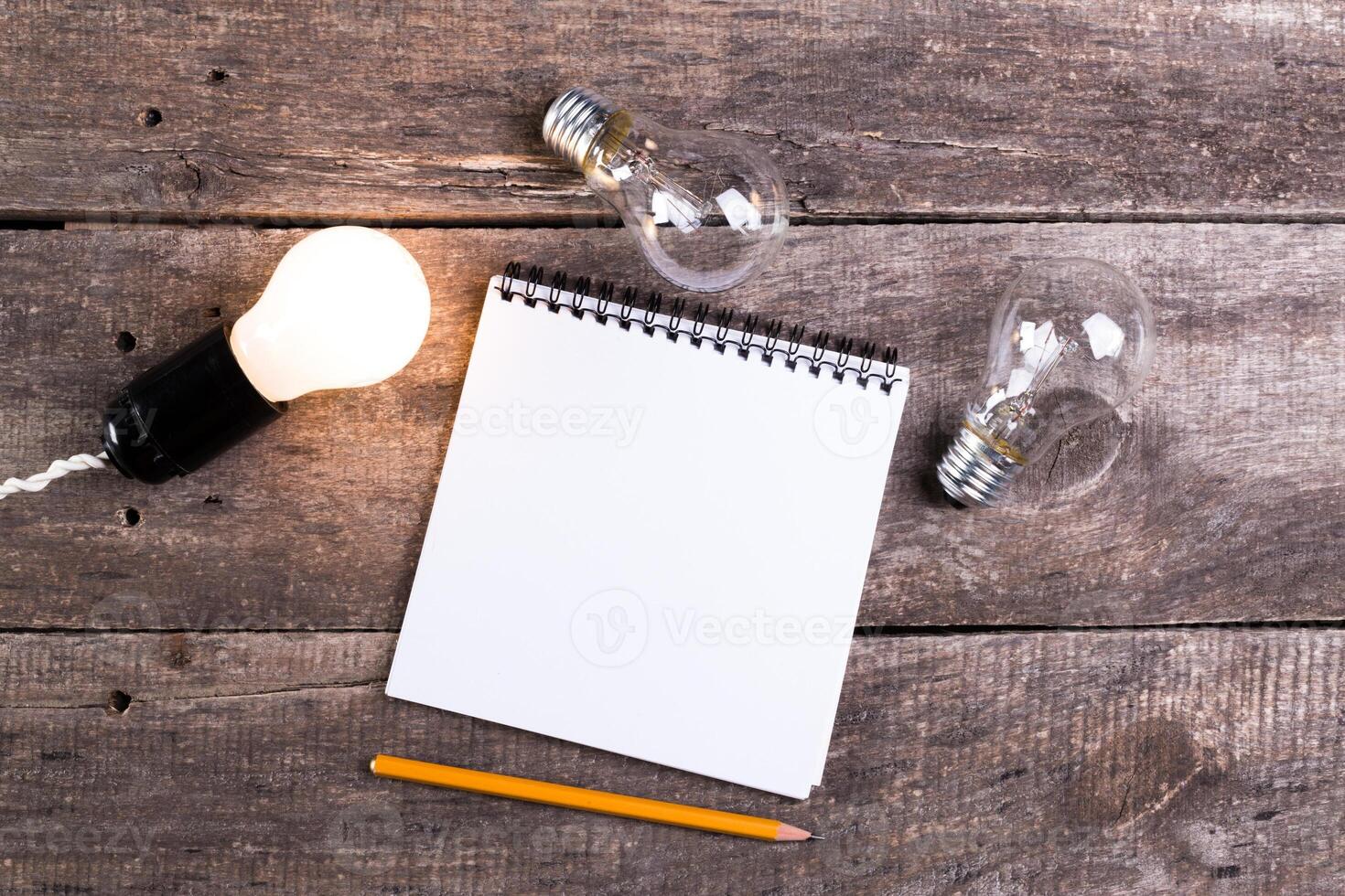 Lightbulb and blank open notepad. Having an idea concept photo