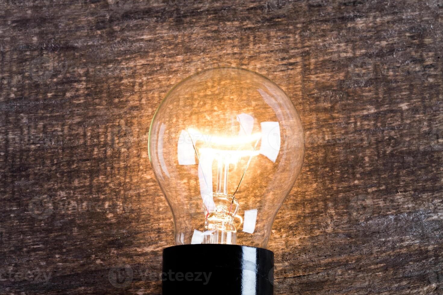 Electrical light bulb over wooden background close up photo