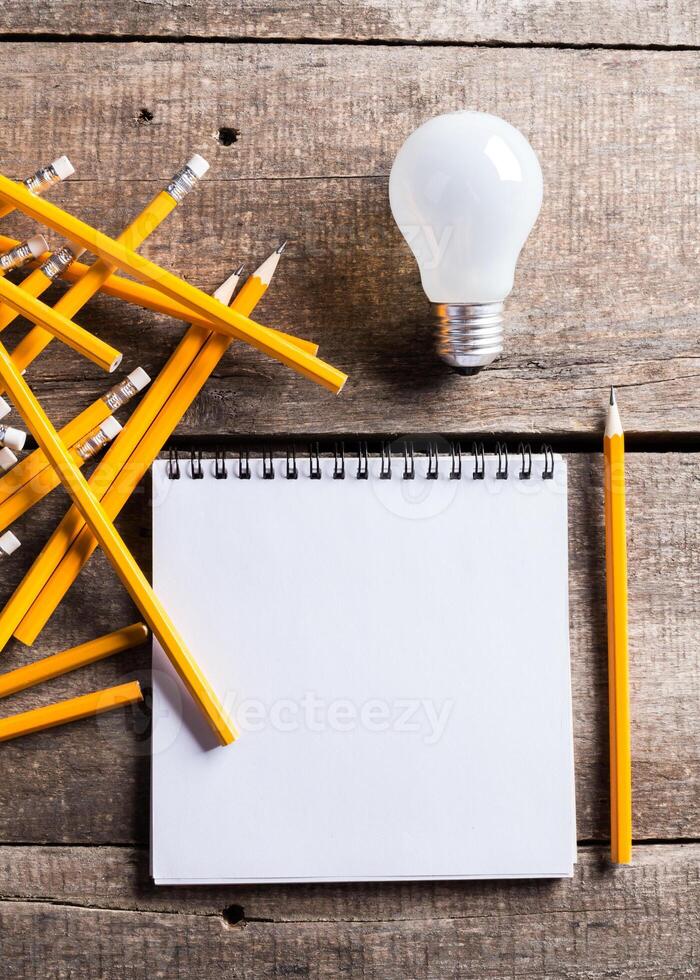 Lightbulb and blank open notepad. Having an idea concept photo