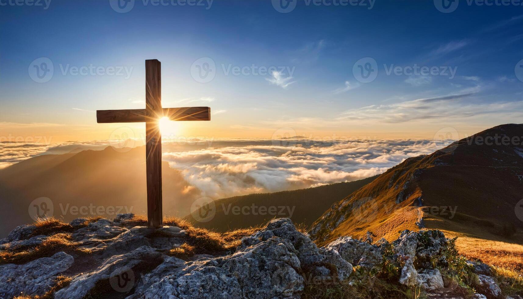 Wooden Cross stands on a rocky Mountain Peak at Sunrise. Sunburst shining through the Cross with Clouds and Mountain Views in the Background. photo