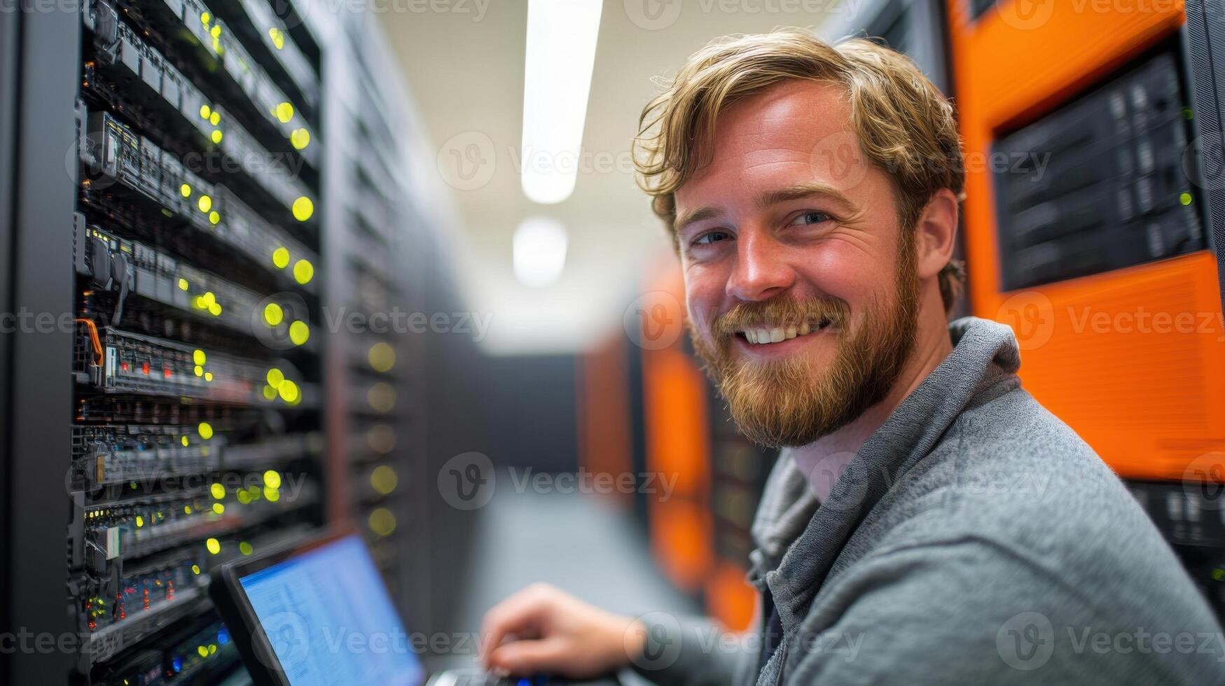 Server room. Man uses laptop. Smiling face. Data center. Technician working. Computer and network. System administrator. Internet technology. Man looks at camera. photo