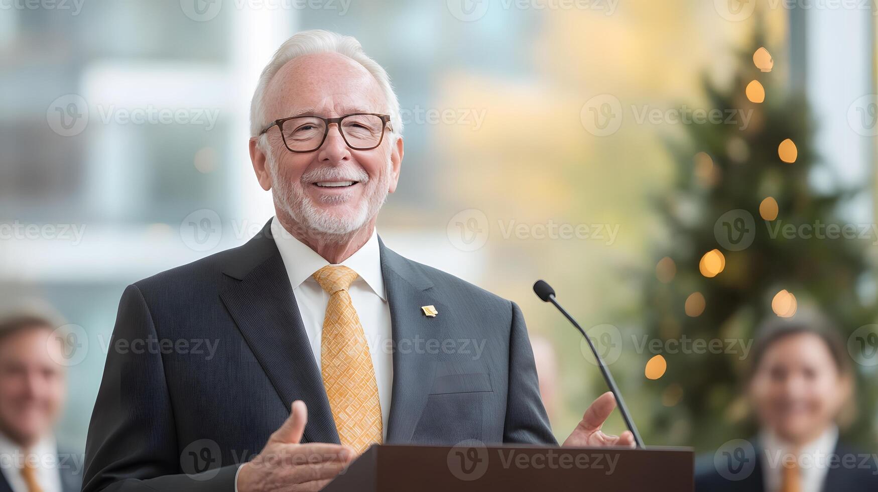 Retiree giving a farewell speech while colleagues applaud in a well-decorated office space photo