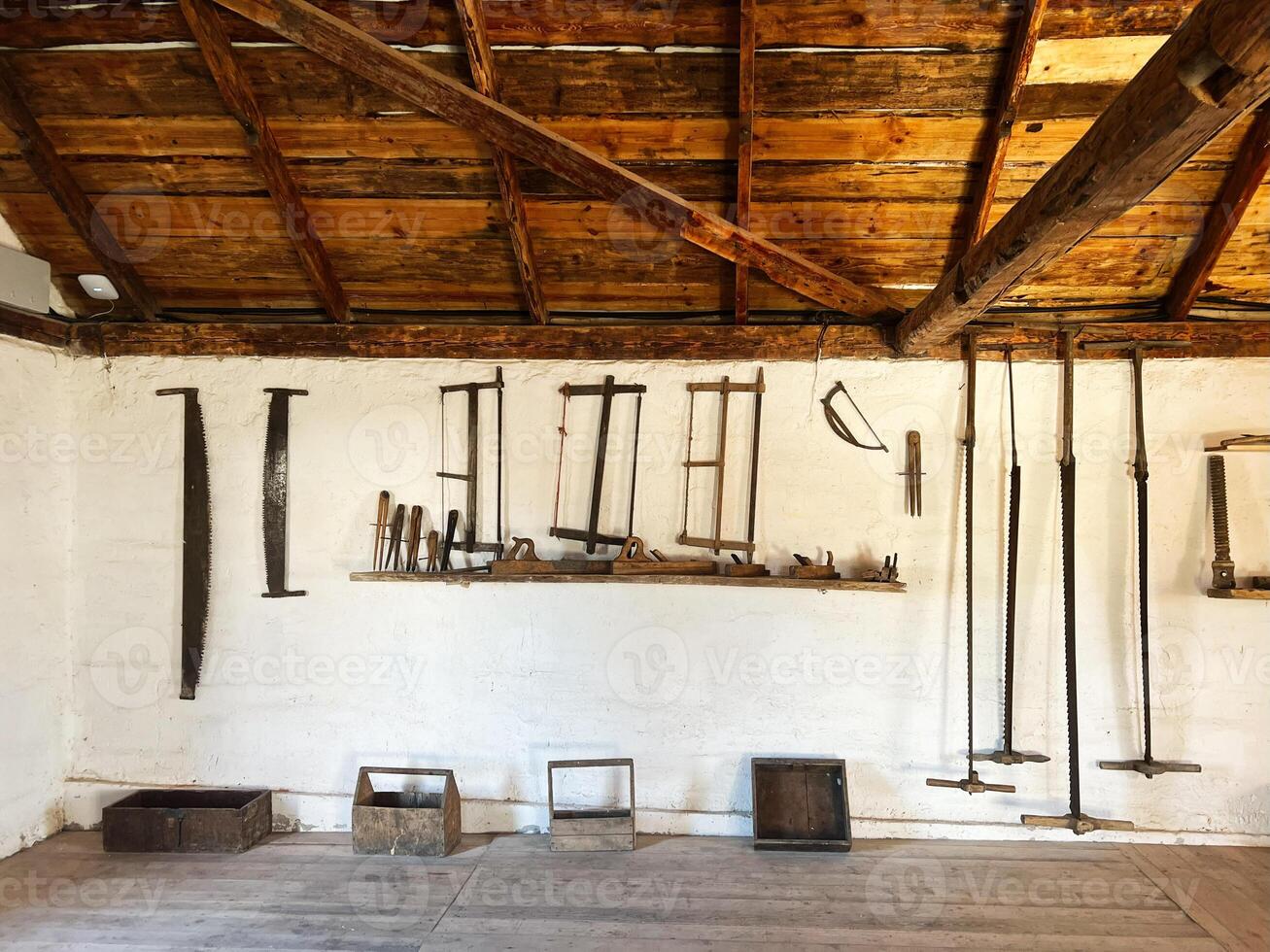 Vintage woodworking tools displayed on a wall in a rustic workshop photo