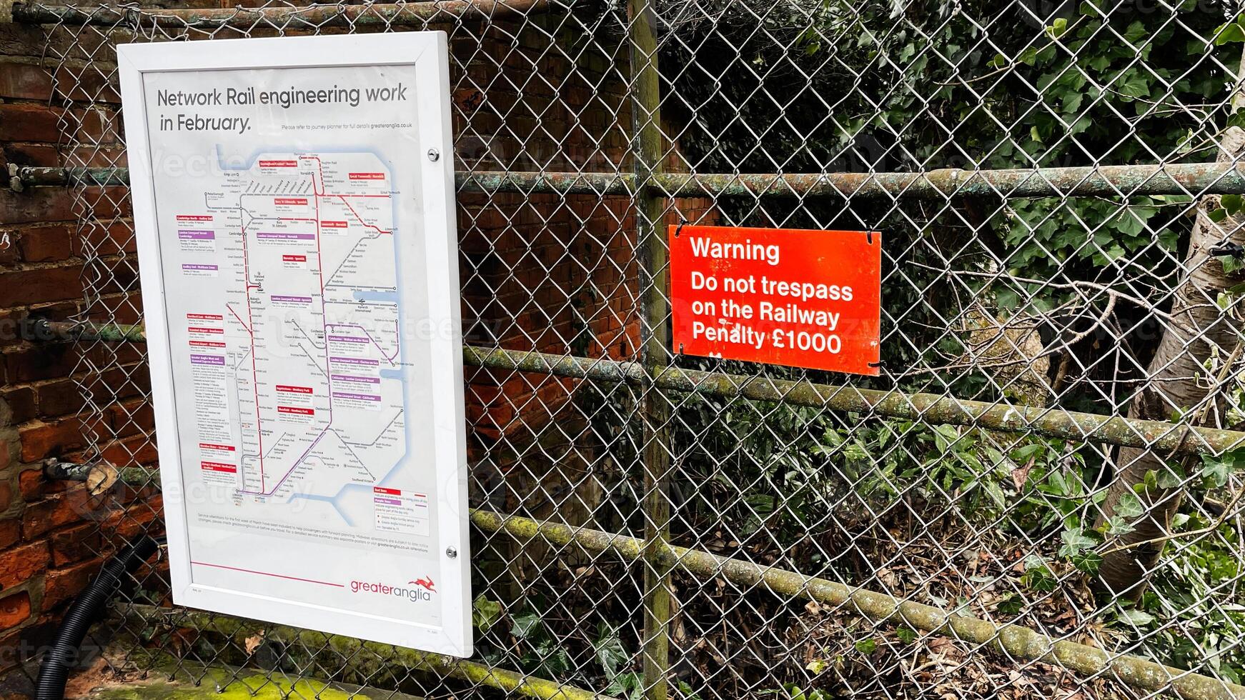 Warning and network rail signage on a chain link fence in Enfield, London photo