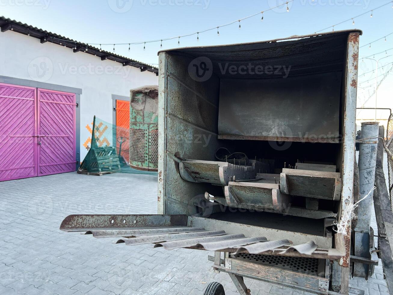 Old agricultural equipment and vibrant barn doors in rustic countryside setting photo
