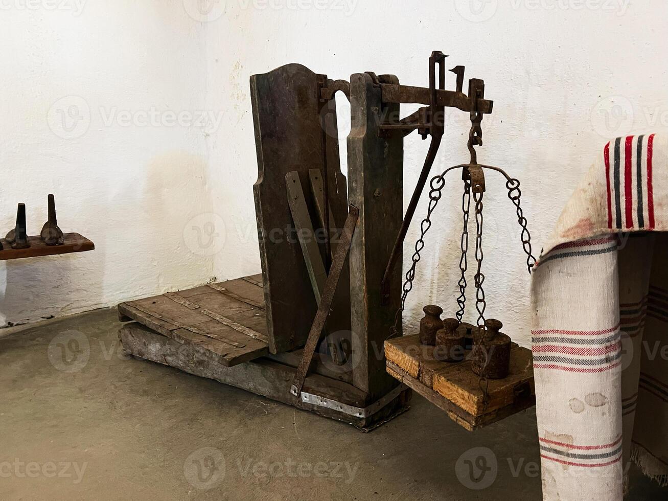 Vintage wooden weighing scale with metal weights in a rustic setting photo